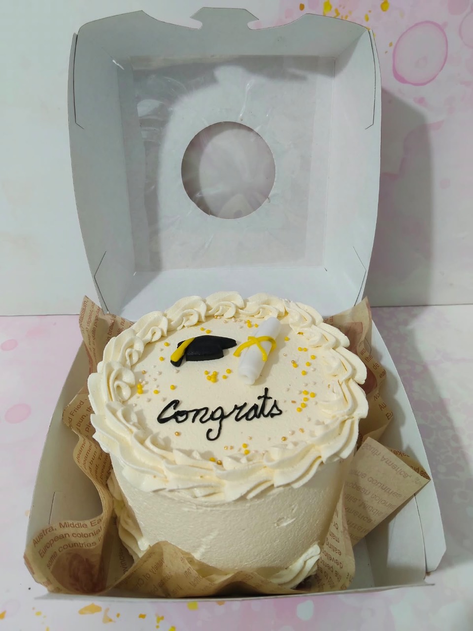 White graduation cake with a cap and diploma